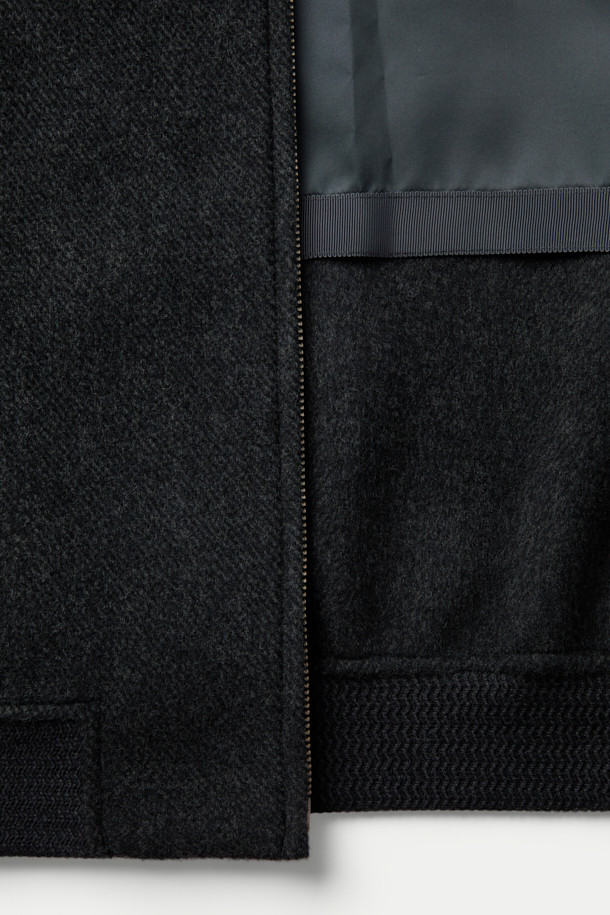 **핸드메이드 블루종**

부드러운 울, 캐시미어, 스웨이드 소재가 조화롭게 어우러져 포근한 착용감을 선사하는 핸드메이드 블루종입니다. 간절기와 겨울철, 데이트룩, 모임룩 등 다양한 TPO에 활용하기 좋으며, 클래식, 미니멀, 캐주얼 스타일을 모두 아우릅니다. 블랙 컬러의 무지 디자인에 세미 루즈핏으로 편안함을 더했으며, 니트 립 마감, 사선 포켓, 스웨이드 배색 디테일이 빈티지 무드를 자아냅니다. 핸드메이드 봉제 방식으로 제작되어 높은 퀄리티를 자랑하는 숏 기장의 집업 블루종입니다.
