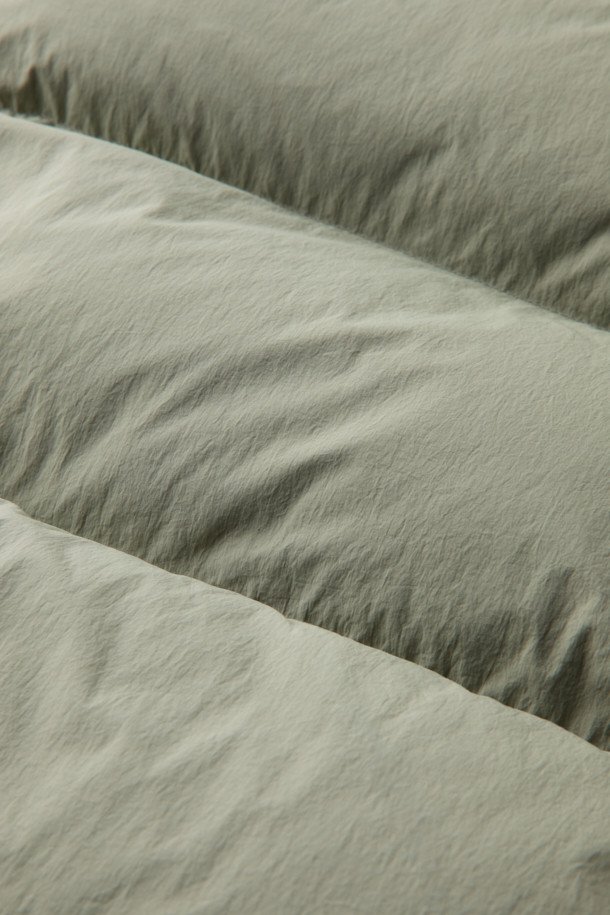 "구스다운 에어트루퍼"는 겨울철 추위를 완벽하게 방어해 줄 남녀 공용 아우터입니다. 보온성이 뛰어난 구스다운 충전재와 튼튼한 나일론 소재를 사용하여, 일상생활은 물론 아웃도어 활동에도 적합합니다. 밀리터리 스타일과 캐주얼 무드를 동시에 느낄 수 있으며, 레귤러핏과 무지 디자인으로 어떤 스타일에도 잘 어울립니다. 카키와 올리브 두 가지 색상으로 출시되었으며, 넉넉한 포켓 디테일과 후드, 방수 기능으로 실용성을 더했습니다. 여행, 캠핑, 등산 등 다양한 TPO에 활용 가능하며, 고프코어 및 미니멀 스타일 연출에도 제격입니다.
