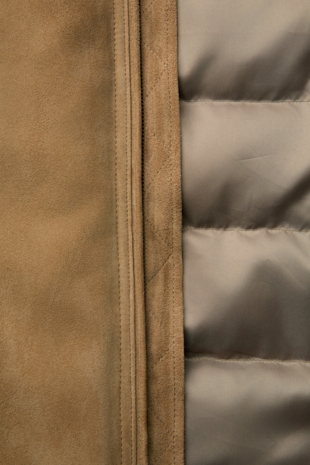 베이지 컬러의 스웨이드 다운 점퍼입니다. 간절기와 초겨울에 적합하며, 클래식하고 미니멀한 스타일을 연출합니다. 부드러운 스웨이드 소재와 두꺼운 두께감으로 포근함을 더하고, 구스다운 충전재를 사용하여 보온성을 높였습니다. 스탠드넥 구조와 니트 시보리 디테일이 돋보이며, 안감과 다운백 분리 설계로 편안함을 제공합니다. 투웨이 지퍼와 긴 소매 기장으로 출근룩에 활용하기 좋습니다.
