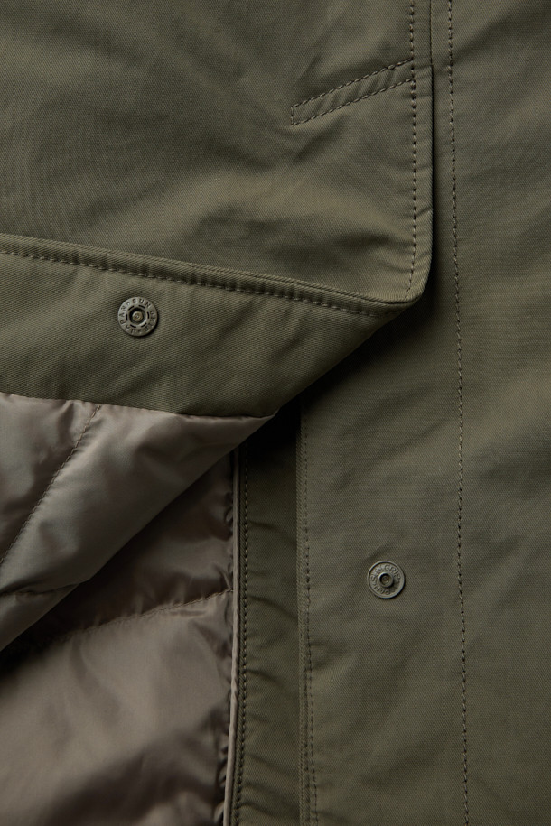 멕켄지 구스코트는 미니멀하고 베이직한 스타일의 겨울용 아우터입니다. 카키와 올리브 두 가지 색상으로 출시되었으며, 무릎 기장의 무지 디자인이 특징입니다. 고밀도 원단과 구스다운 충전재를 사용하여 보온성을 높였으며, 탈부착 가능한 베스트 패널과 양털 넥으로 다양한 스타일 연출이 가능합니다. 레귤러핏과 세미오버핏 두 가지 핏으로 제공되며, 지퍼와 히든 버튼으로 여밈 방식을 더했습니다. 출근룩과 여행룩에 모두 활용하기 좋은, 부드러운 촉감의 구스다운 코트입니다.
