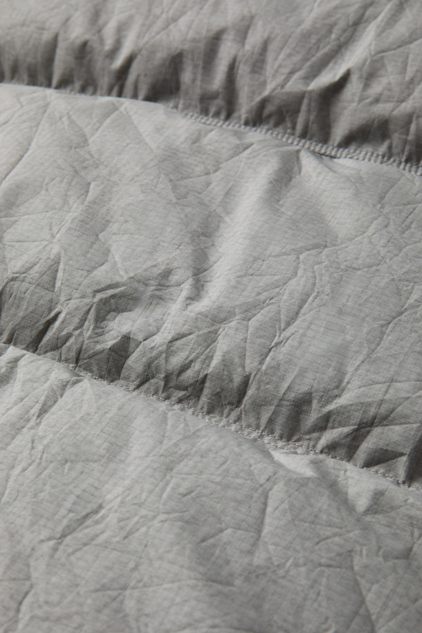 이탈리안 테크니컬 패브릭 크랙 레이어 숏패딩은 겨울철 일상 및 여행, 산책 시 캐주얼하고 미니멀한 스타일을 연출하기에 좋습니다. 3-Layer 기능성 원단과 피그 워싱 가공으로 빈티지한 외관을 자랑하며, 방수, 방풍, 수분 배출 기능으로 쾌적함을 유지합니다. 덕다운 충전재와 두꺼운 두께감으로 보온성을 높였으며, 세미루즈핏으로 편안한 착용감을 선사합니다. 그레이 컬러에 무지 패턴, 사선 포켓, 니트 립 트리밍 및 세로/가로 퀼팅 믹스 디테일이 돋보이는 숏패딩입니다.
