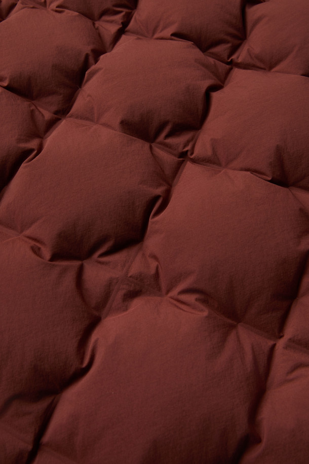 CMF 우븐 다운 베스트는 가을, 겨울철 일상 및 아웃도어 활동에 적합한 남녀 공용 베스트입니다. 브라운 컬러의 퀼팅 패턴과 크롭 기장으로 캐주얼, 스포티, 미니멀 스타일을 연출할 수 있습니다. CMF WOVEN 기술을 적용하여 다운팩 없이 X자 구조로 직조되었으며, 다운 90%, 페더 10% (700FP)의 안감과 다운 본딩 처리로 보온성을 높였습니다. 얇고 가벼운 나일론, 폴리우레탄 소재에 넉넉한 두께감과 부드러운 촉감, 사선 포켓 디자인이 특징입니다. 캠핑룩으로 활용하기 좋으며 스냅 여밈 방식으로 편안하게 착용할 수 있습니다.
